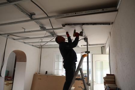 Un artisan installe un faux plafond en vue de la pose d'une isolation thermique dans une maison à Cognocoli-Monticchi, en Corse.