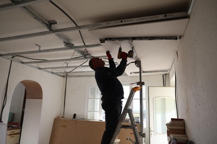 Un artisan installe un faux plafond en vue de la pose d'une isolation thermique dans une maison à Cognocoli-Monticchi, en Corse.