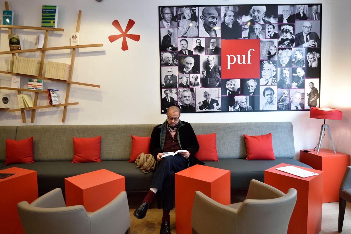 Un homme regarde un livre avant d'imprimer son propre exemplaire à la nouvelle librairie des Presses Universitaires de France (PUF) à Paris, le 16 mars 2016.