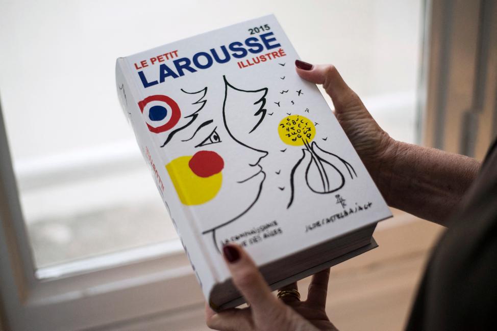Une femme tient un exemplaire de la nouvelle édition du dictionnaire français « Petit Larousse ».