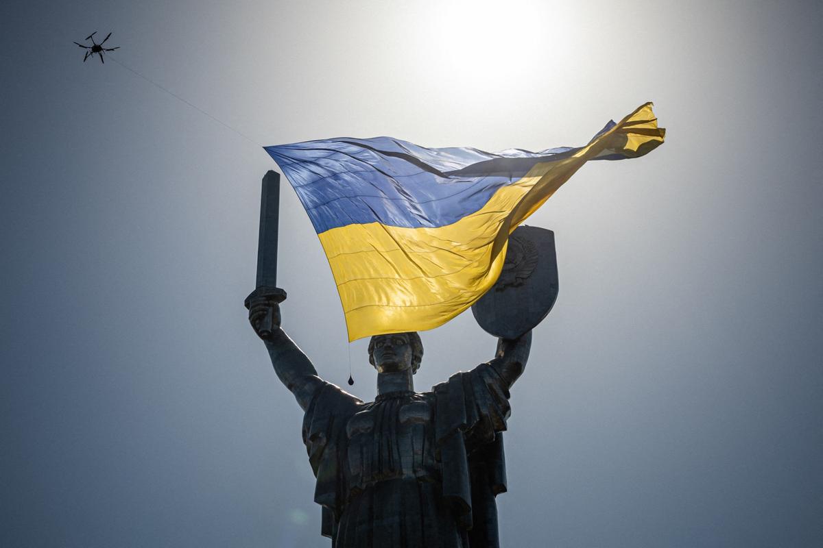 Un drone arborant un drapeau national ukrainien géant passe au-dessus du monument de la Mère Patrie lors du jour de l'indépendance de l'Ukraine, le 24 août 2022.