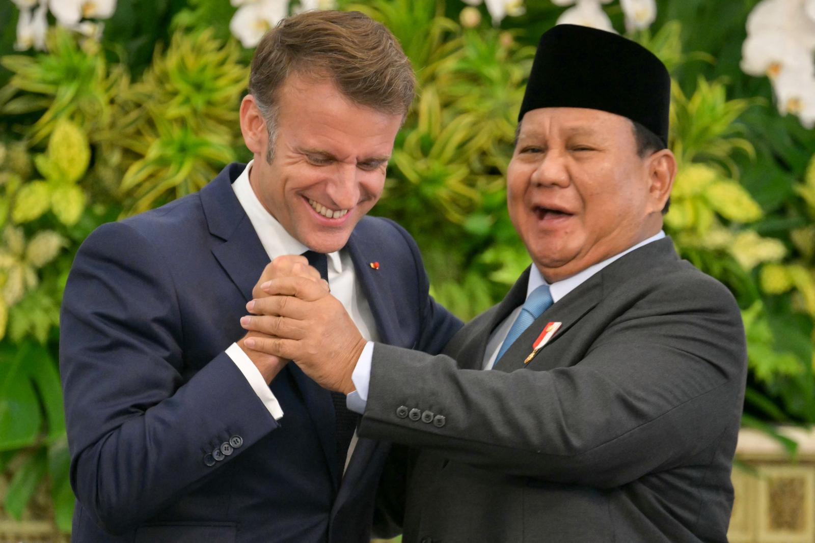 Emmanuel Macron et le président indonésien Prabowo Subianto se serrent la main lors d'une conférence de presse au Palais de Merdeka à Jakarta en Mai 28, 2025. (Photo by BAY ISMOYO / AFP)
