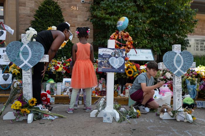 Des personnes se rendent à un mémorial devant l'église catholique de l'Annonciation, le 29 août 2025 à Minneapolis, dans le Minnesota. Le 27 août, une femme transgenre a tiré à travers les vitraux de l'église pendant une messe, tuant deux enfants et en blessant au moins 17 autres.