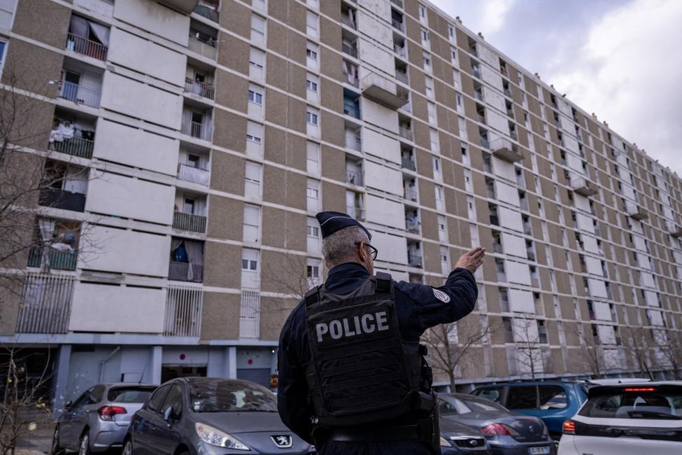 Un policier fait un geste lors d'une vaste opération antidrogue dans la cité « La Cité des Oliviers A », dans le quartier de Sainte-Marthe, au nord de Marseille, le 9 décembre 2025.