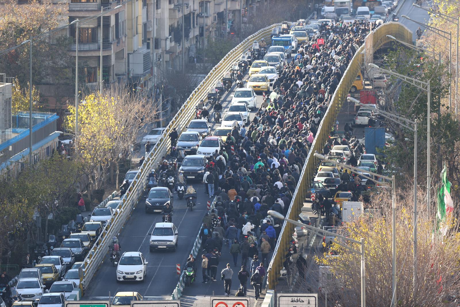 Des commerçants traversent un pont à Téhéran le 29 décembre 2025 lors d'une manifestation contre la situation économique et la chute du rial iranien.