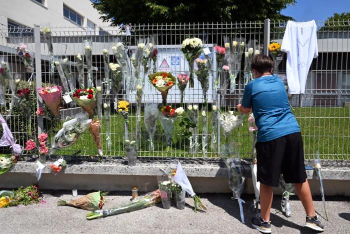 Un élève accroche des fleurs sur la clôture du collège Françoise Dolto à Nogent le 11 juin 2025, un jour après l'arrestation d'un élève de collège après avoir tué un assistant scolaire de 31 ans avec un couteau lors d'une fouille de sac.