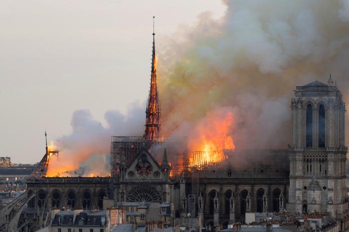 De la fumée s'élève tandis que les flammes brûlent le toit de la cathédrale Notre-Dame de Paris, le 15 avril 2019, dans la capitale française, Paris.