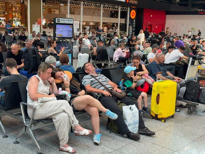 Des passagers attendent leur vol à l'aéroport international Sheremetyevo, dans la banlieue de Moscou, le 28 juillet 2025, après d'importantes perturbations suite à une cyberattaque.