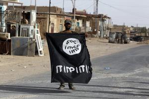 Un membre irakien des Hachd al-Chaabi (Unités de mobilisation populaire) porte un drapeau du groupe État islamique dans la ville d'al-Qaim, dans l'ouest de l'Irak, le 3 novembre 2017. Image d'illustration