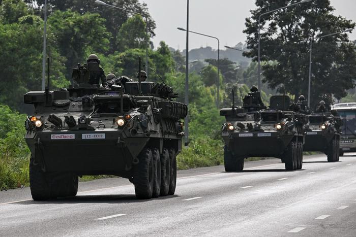Des soldats de l'armée royale thaïlandaise sont photographiés sur des véhicules blindés sur une route de la province de Chachoengsao, le 24 juillet 2025.