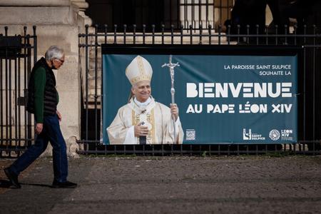 Une personne passe devant une banderole portant l'inscription « La paroisse Saint-Sulpice accueille le pape Léon XIV », quatre jours avant la visite apostolique du pontife à Paris, le 21 septembre 2026.