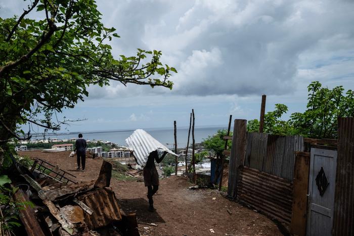 Un homme marche au milieu des maisons détruites dans la ville de Mamoudzou, à Mayotte, le 2 janvier 2025.