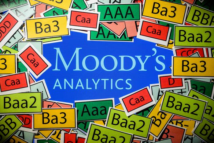 Cette photographie d'illustration montre un écran affichant le logo de l'agence de notation Moody's Analytics et les signes des notations utilisées par les agences de notation, à Toulouse le 18 mars 2025.