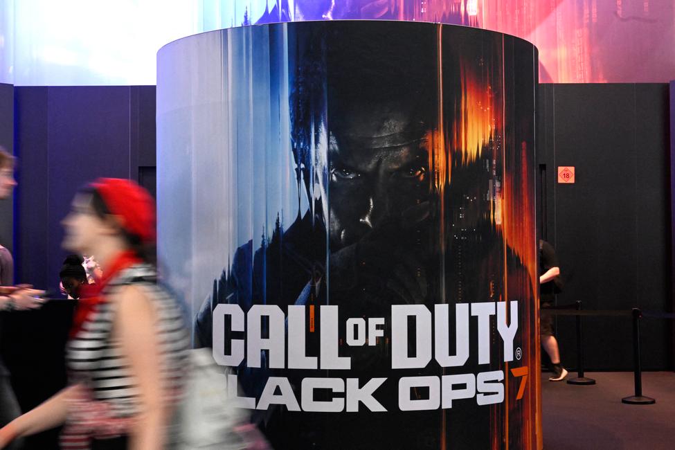 Une visiteuse passe devant une affiche de Call of Duty: Black Ops 7 d'Activision lors du salon des jeux vidéo Gamescom au parc des expositions de Cologne, dans l'ouest de l'Allemagne, en août 2025 (Photo par Ina FASSBENDER / AFP)