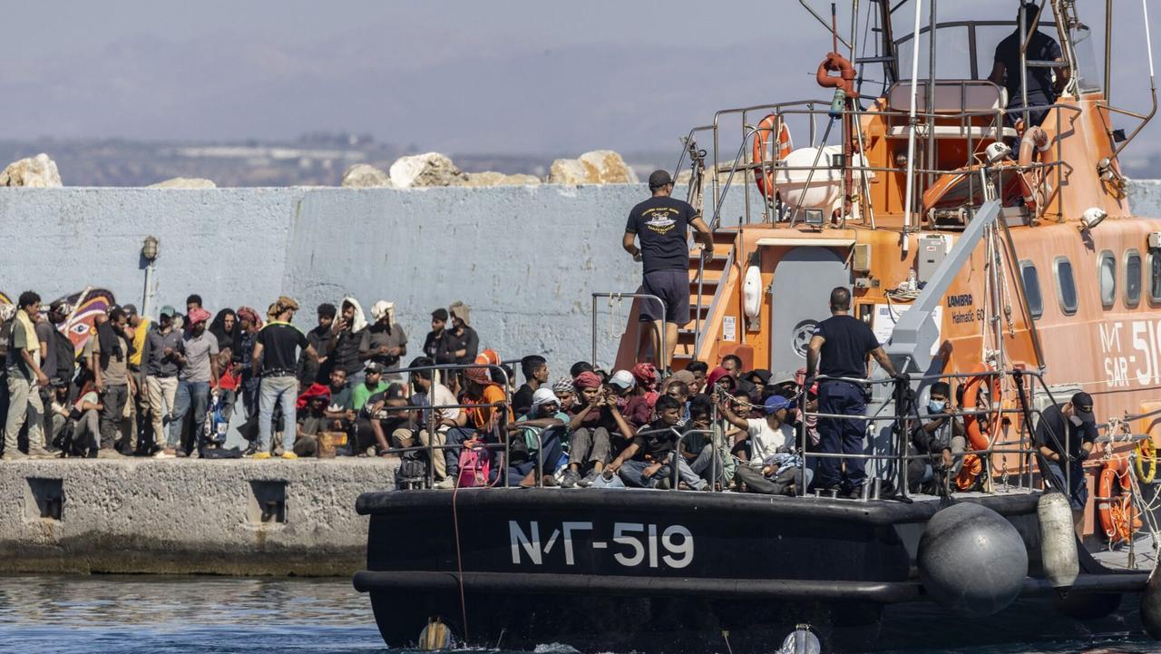 Des migrants secourus en mer au large de l'île grecque de Crète débarquent d'un navire de sauvetage des garde-côtes grecs dans le port d'Agia Galini avant d'être transférés le 6 juillet 2025.