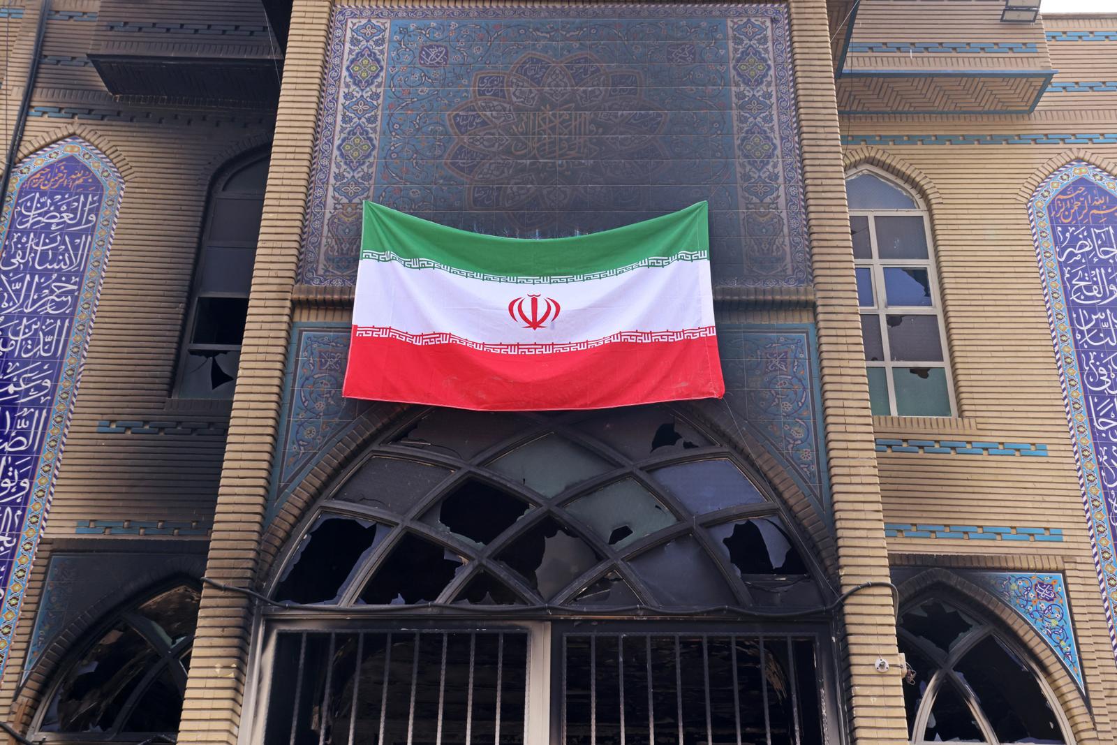 Cette photographie, prise lors d'une visite organisée pour les médias étrangers, montre un drapeau national iranien hissé sur la mosquée Beheshti, endommagée lors des récentes manifestations, à Téhéran, le 21 janvier 2026.
