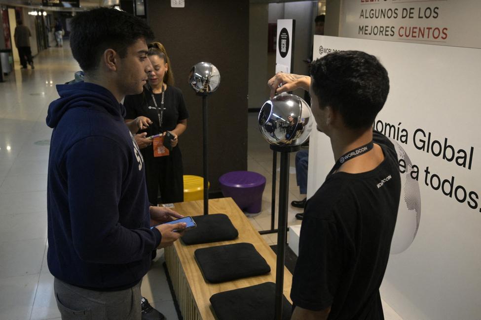 À Buenos Aires, le 22 mars 2024, un homme se fait scanner l'iris à l'aide d'une sphère, un dispositif de lecture de données biométriques, en échange de la cryptomonnaie Worldcoin.