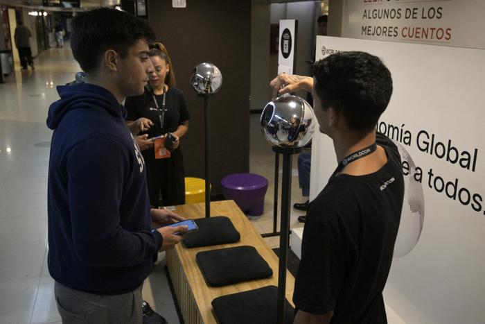 À Buenos Aires, le 22 mars 2024, un homme se fait scanner l'iris à l'aide d'une sphère, un dispositif de lecture de données biométriques, en échange de la cryptomonnaie Worldcoin.