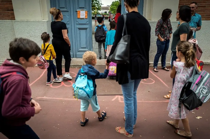 Des parents amènent leurs enfants à l'école.