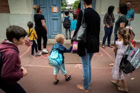 Des parents amènent leurs enfants à l'école.