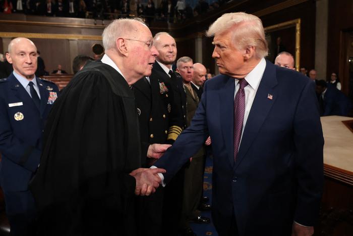 Donald Trump serre la main d'Anthony Kennedy, juge à la retraite de la Cour suprême, après une allocution au Capitole, le 4 mars 2025 à Washington.