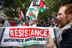 Des manifestants scandent des slogans en brandissant une banderole « Résistance antisioniste anticolonialiste » lors d'une manifestation « contre le racisme et l'islamophobie », organisée par différentes organisations à Paris le 21 avril 2024. 