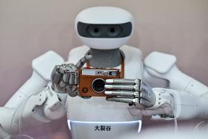 Un robot humanoïde s'apprête à prendre une photo avec un appareil Instax lors de la Conférence mondiale sur l'intelligence artificielle (WAIC) à Shanghai, le 18 juillet 2026.