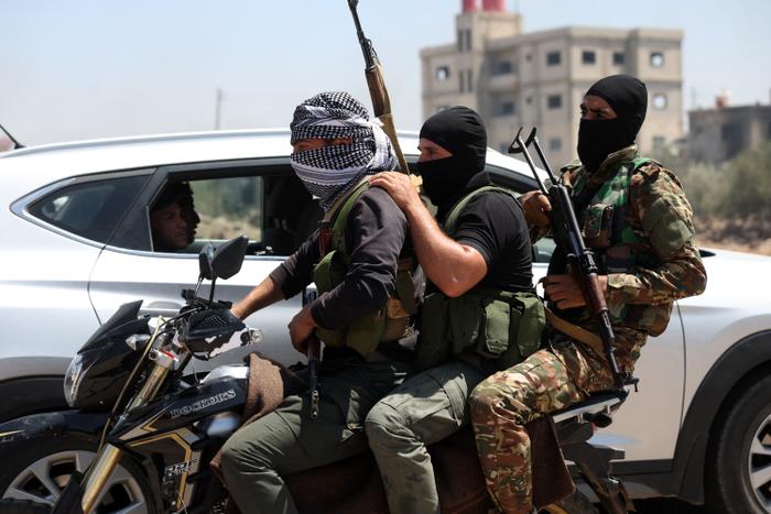 Des combattants des tribus bédouines conduisent une moto dans le village d'al-Mazraa, dans le gouvernorat de Sweida, au sud de la Syrie.