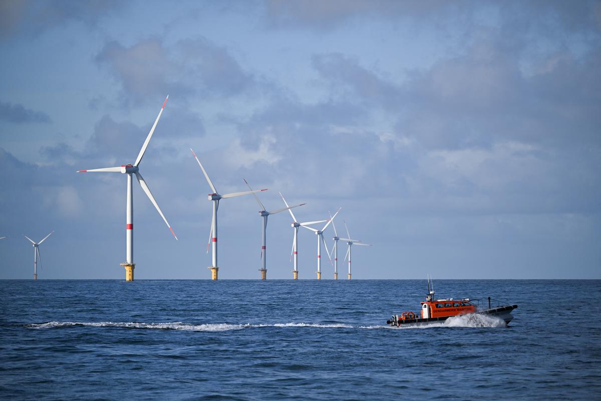 Un navire de la gendarmerie maritime passe devant un parc éolien, au large de Fécamp, dans le nord-ouest de la France, le 18 octobre 2024.
