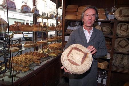 Lionel Poilane pose avec son pain Poilane, le 3 septembre 1999, dans sa célèbre boulangerie parisienne. 