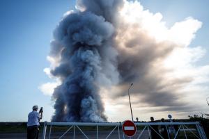 Un habitant prend en photo la fumée d'un incendie qui ravage les complexes logistiques de la société russe de commerce électronique Wildberries, à Elektrostal, près de Moscou, le 18 juillet 2026.