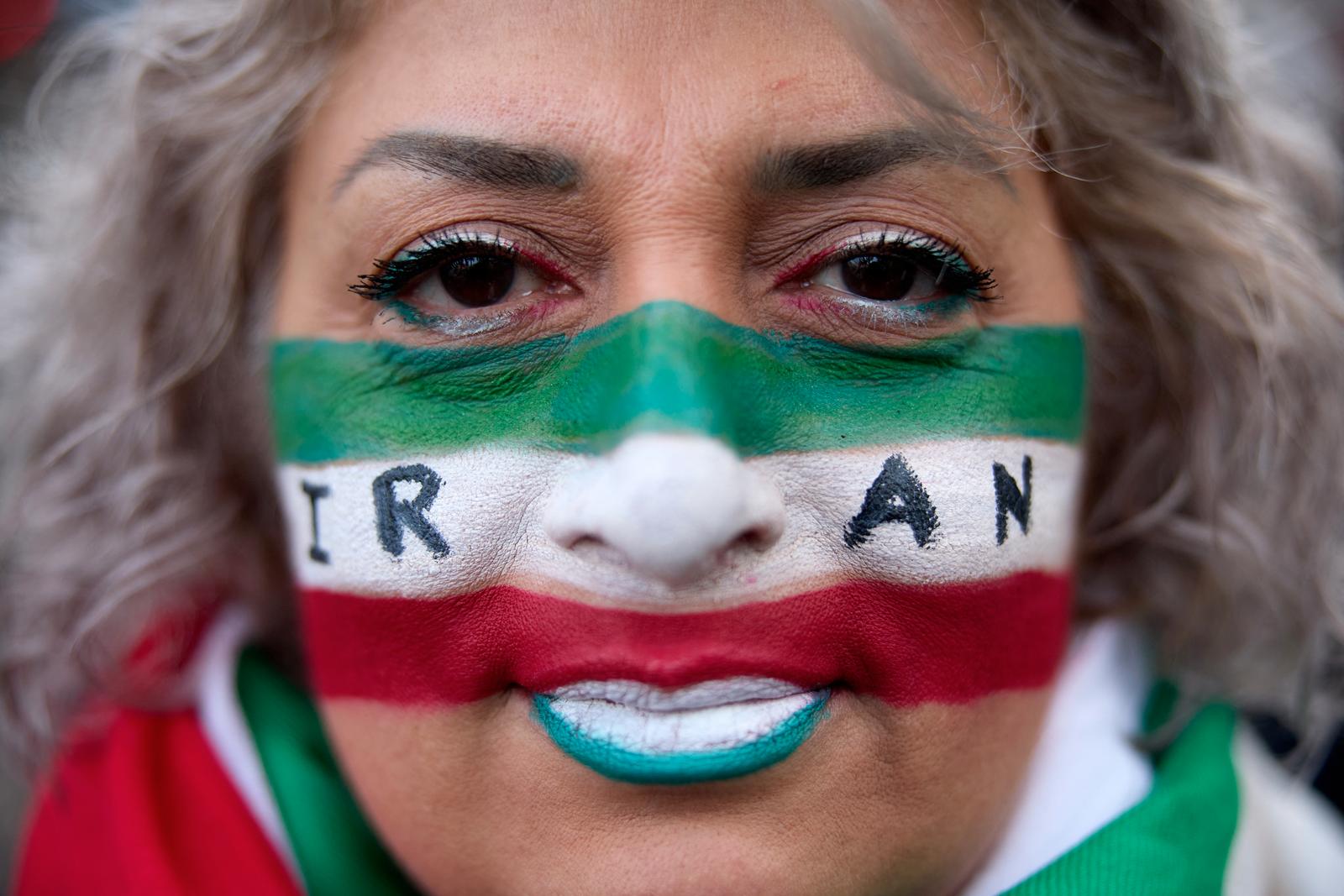 Une manifestante a le visage peint aux couleurs du drapeau iranien et avec le mot « Iran » lors d'une manifestation de soutien aux rassemblements de masse dénonçant la république islamique en Iran à Paris, le 11 janvier 2026.