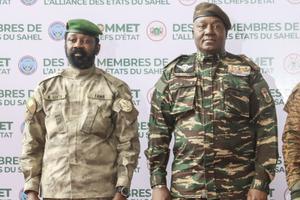 Le chef du gouvernement militaire du Niger, le général Abdourahamane Tiani (à droite), et le colonel malien Assimi Goita (à gauche) posent pour une photo à leur arrivée à Niamey, avant le sommet de la Confédération des États du Sahel (AES), le 6 juillet 2024.