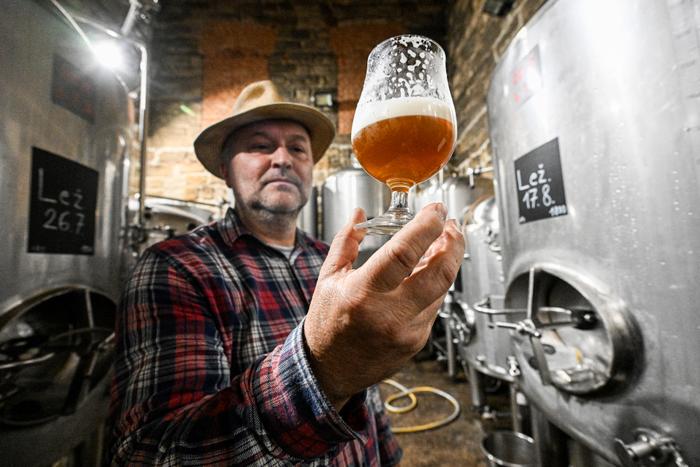 Un brasseur de la brasserie Renaissance rénovée du village de Lobec, un verre à la main, déguste une bière le 17 août 2023, dans le village de Lobec, en Bohême centrale, au nord de la République tchèque.