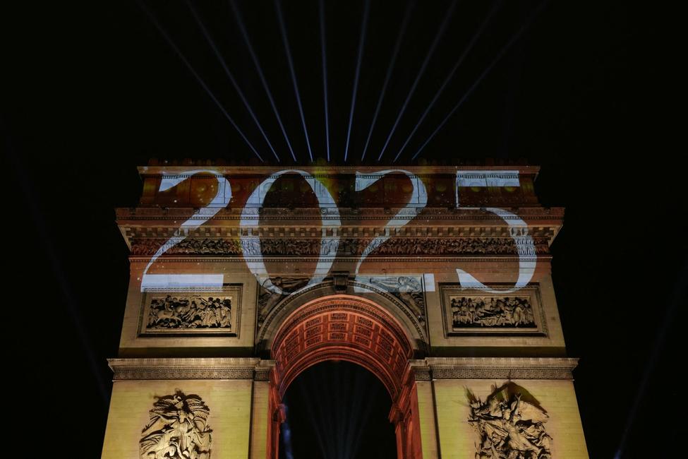 L'Arc de Triomphe illuminé sur l'avenue des Champs-Élysées à Paris, le 1er janvier 2025.