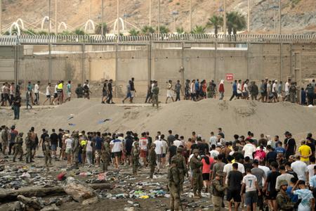 Des soldats espagnols contrôlent le passage des migrants qui retournent au Maroc après avoir franchi la frontière pour entrer dans l'enclave espagnole de Ceuta, le 31 juillet 2026.