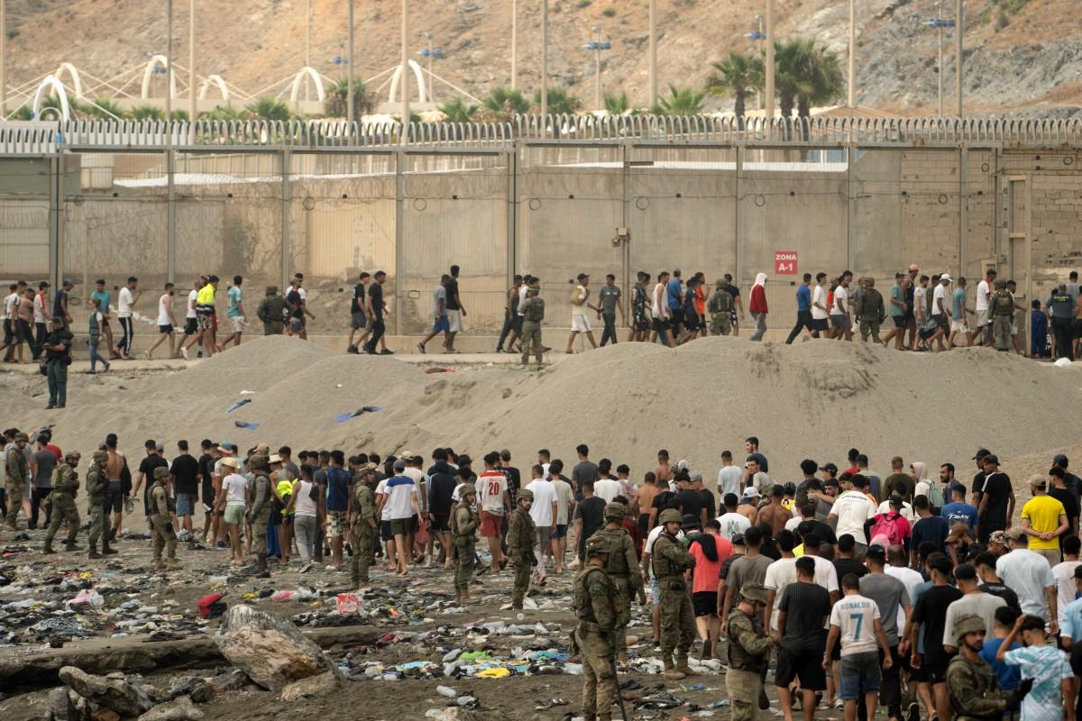 Des soldats espagnols contrôlent le passage des migrants qui retournent au Maroc après avoir franchi la frontière pour entrer dans l'enclave espagnole de Ceuta, le 31 juillet 2026.