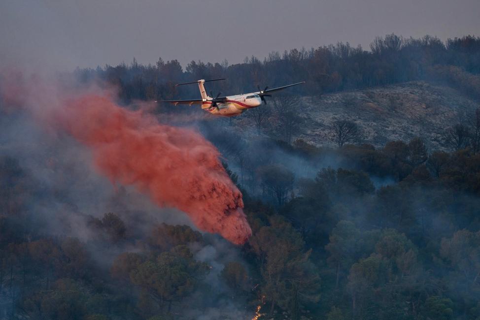 Un avion de lutte contre les incendies DASH largue un produit ignifuge lors d'un incendie de forêt près de Bizanet, dans le sud-ouest de la France, le 29 juin 2025.