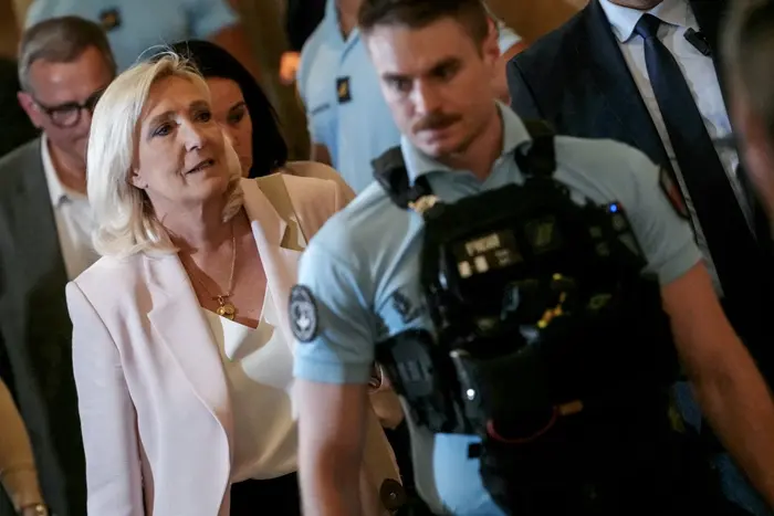 Marine Le Pen (à gauche), présidente du groupe parlementaire Rassemblement National, quitte la Cour d'appel de Paris le 7 juillet 2026 après le verdict rendu dans le procès en appel des anciens et actuels membres du RN accusés de détournement de fonds publics européens dans une affaire de création d'emplois fictifs au Parlement européen. La cour d'appel a condamné Marine Le Pen, dirigeante de l'extrême droite française, à un an de détention sous bracelet électronique pour fraude aux emplois fictifs au Parlement européen, compromettant ainsi sa candidature à la présidence en avril prochain. Elle a également été interdite de se présenter à une élection pendant 15 mois, une interdiction qui devait expirer cette année. (Photo : Dimitar DILKOFF / AFP)