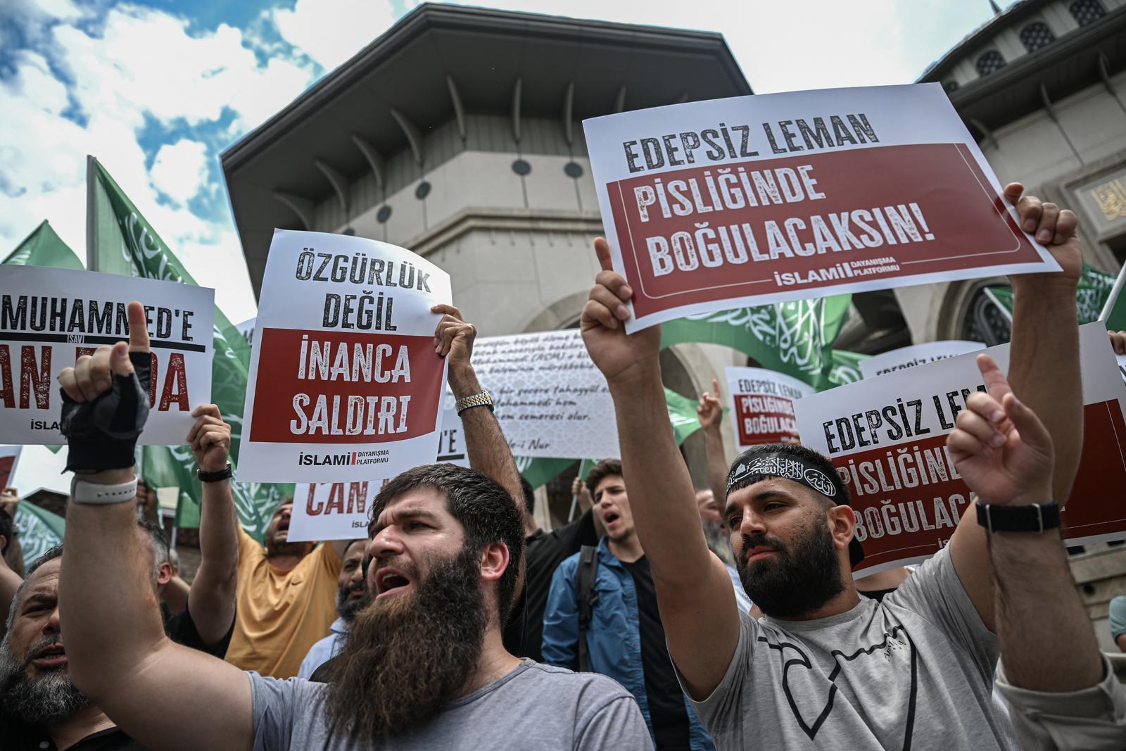 Des manifestants brandissent des pancartes, dont l’une où l’on peut lire « LeMan immoral, tu te noieras dans ta saleté » (à droite), pour protester contre les dessinateurs d’un magazine satirique accusé d’avoir publié une caricature du prophète Mahomet, devant la mosquée Taksim à Istanbul, le 1ᵉʳ juillet 2025.