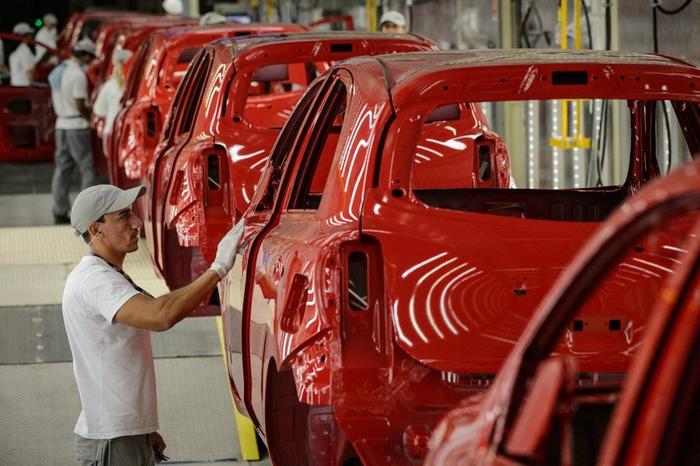 Des travailleurs dans une usine automobile.