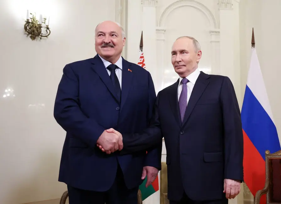 Le président russe Vladimir Poutine serre la main du président biélorusse Alexandre Loukachenko lors de leur rencontre en marge du sommet informel des dirigeants de la Communauté des États indépendants (CEI) à Saint-Pétersbourg, le 21 décembre 2025.