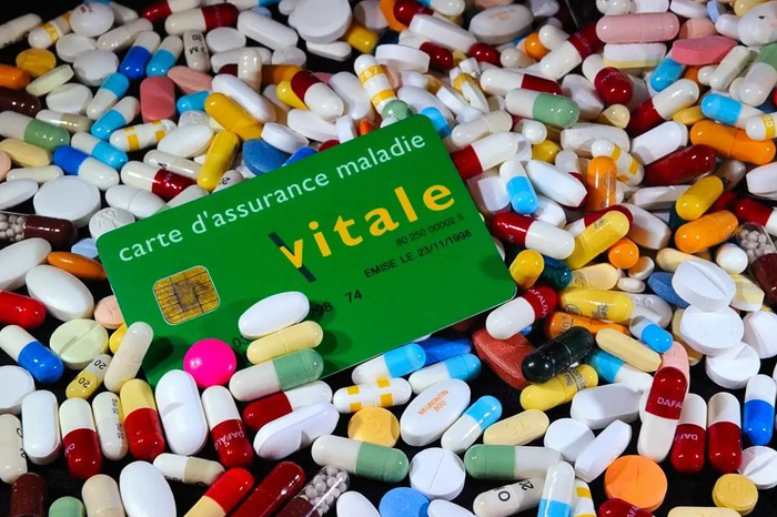 Une carte vitale entourée de nombreux médicaments.