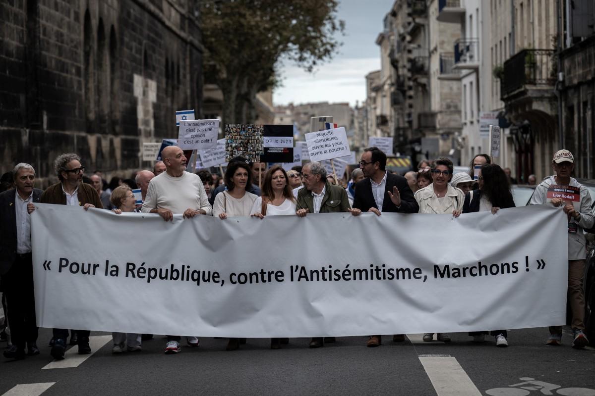 People hold a banner reading "For the Republic against antisemitism, let�s walk" during a white march in tribute to the victims of the October 7 attack on Israel by Palestinian militant group Hamas in Bordeaux, southwestern France, on October 6, 2024. - October 7, 2024 will mark the first anniversary of the devastating October 7 Hamas attack that sparked the Gaza war and has now engulfed neighbouring Lebanon, creating a perilous regional crisis. (Photo by Philippe LOPEZ / AFP)