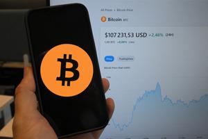 Cette photographie d'illustration montre le logo de la crypto-monnaie Bitcoin affiché sur un smartphone à côté d'un écran affichant un graphique de trading à Bruxelles le 17 décembre 2024.