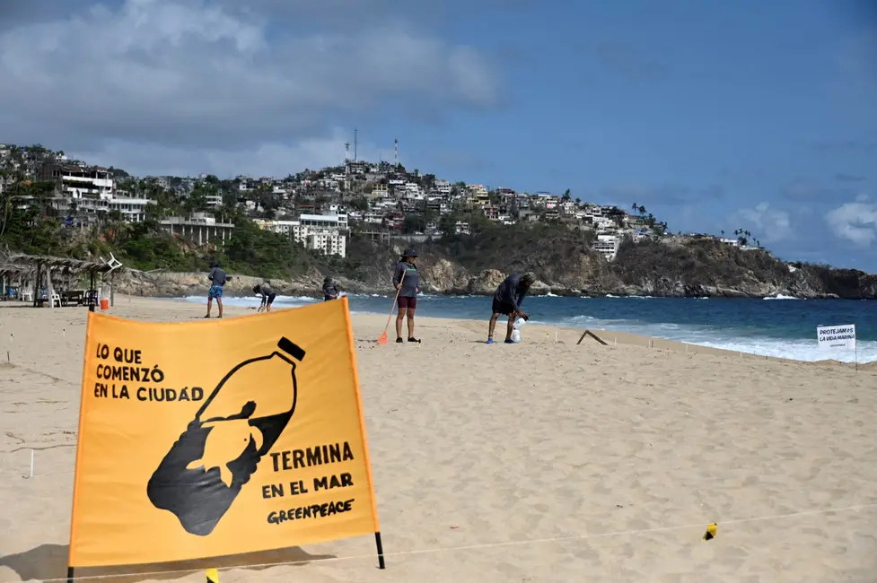Des militants de l'organisation environnementale GreenPeace dessinent un message dans le sable pour sensibiliser le public à la protection des tortues et des océans, dans le cadre d'une campagne intitulée « Océans sans plastique », sur la plage Pie de la Cuesta à Acapulco, dans l'État de Guerrero, au Mexique, le 15 juin 2024. (Photo de Francisco ROBLES / AFP)