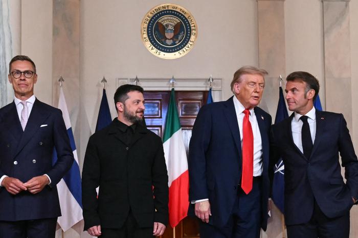 Le président finlandais Alexander Stubb, le président ukrainien Volodymyr Zelensky, le président américain Donald Trump et le président français Emmanuel Macron posent pour une photo de famille avec les dirigeants européens dans le Cross Hall de la Maison Blanche à Washington, le 18 août 2025.