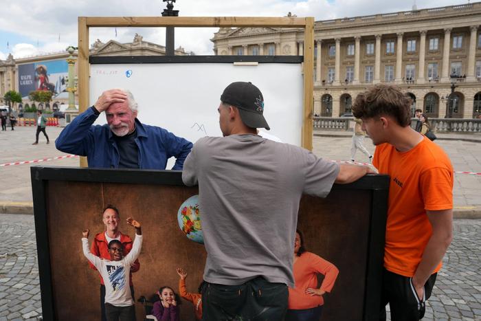 Le photographe français Yann Arthus-Bertrand (à gauche) réagit alors que son exposition de photographies en plein air aurait été vandalisée lors des célébrations des supporters du PSG suite à la victoire de leur équipe en Ligue des champions, place de la Concorde à Paris le 7 mai 2026.