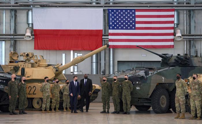 Le secrétaire américain à la Défense Lloyd Austin et le ministre polonais de la Défense Mariusz Blaszczak posent avec des soldats polonais et américains à la 33e base aérienne de l'armée de l'air polonaise près de Powidz, le 18 février 2022.