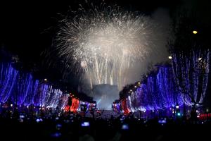Des feux d'artifice illuminent le ciel au-dessus de l'Arc de Triomphe, place de l'Étoile, dans le centre de Paris, pour célébrer le Nouvel An, peu après minuit le 1er janvier 2026.